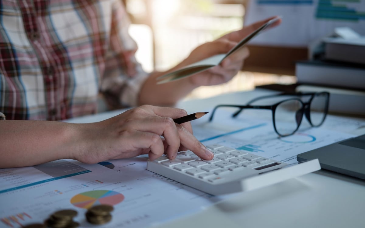 Young woman checking bills, taxes, bank account balance and calculating credit card expenses. Family expenses concept.
