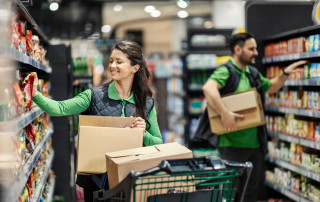 Employees putting products on shelves in supermarket.