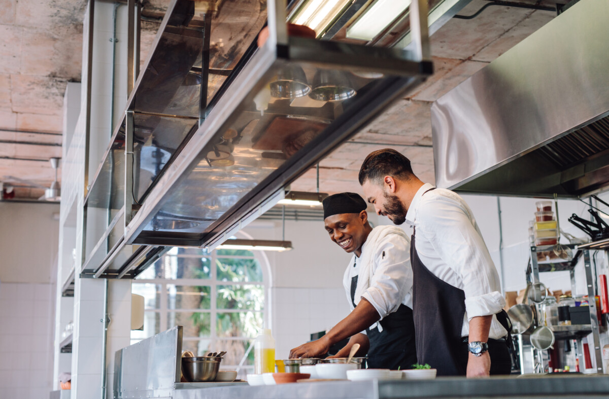 cooks preparing food in restaurant kitchen