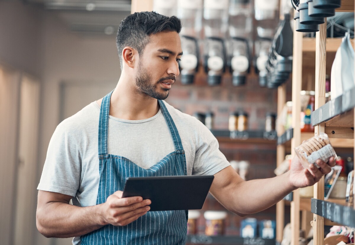 man checking shelf stock in cafe