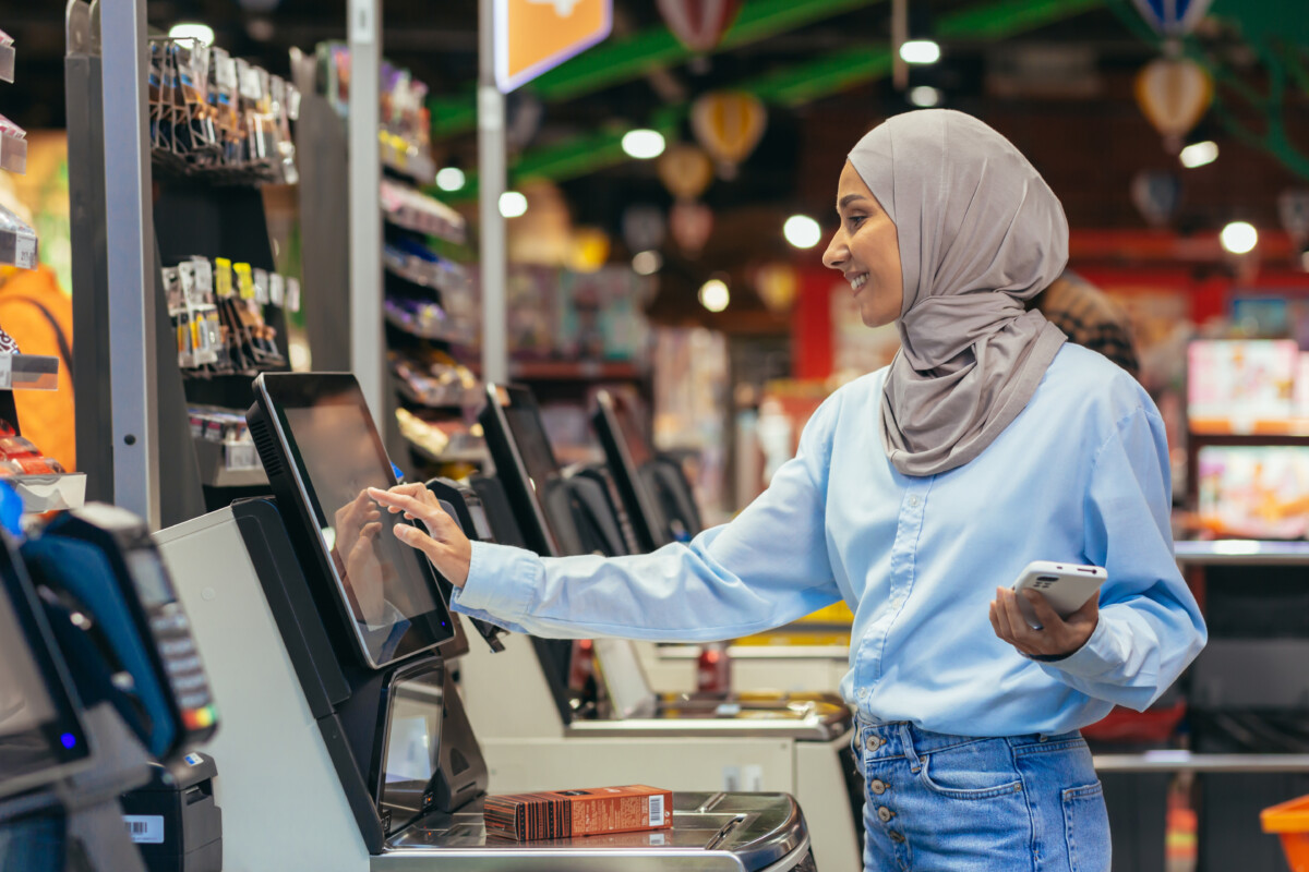 A woman in a supermarket at a self-service checkout