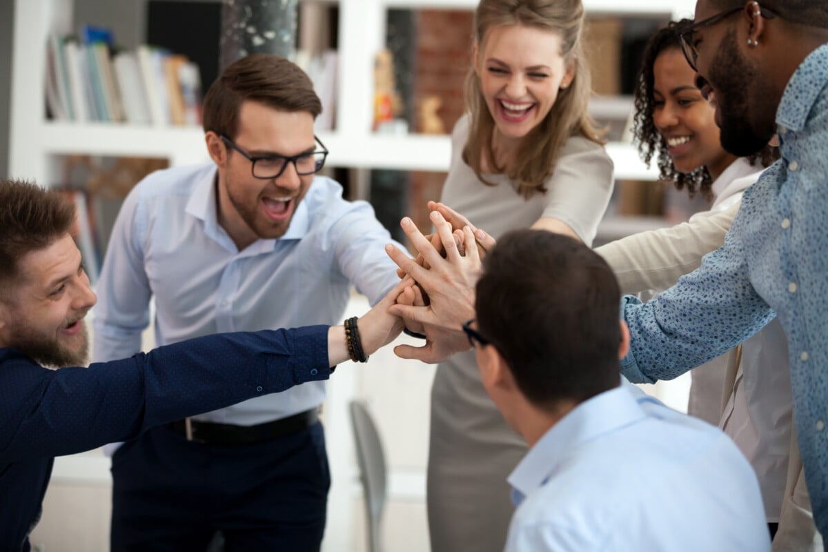 Employee Wellbeing & Engagement Intelligence - Excited motivated team give high five in office