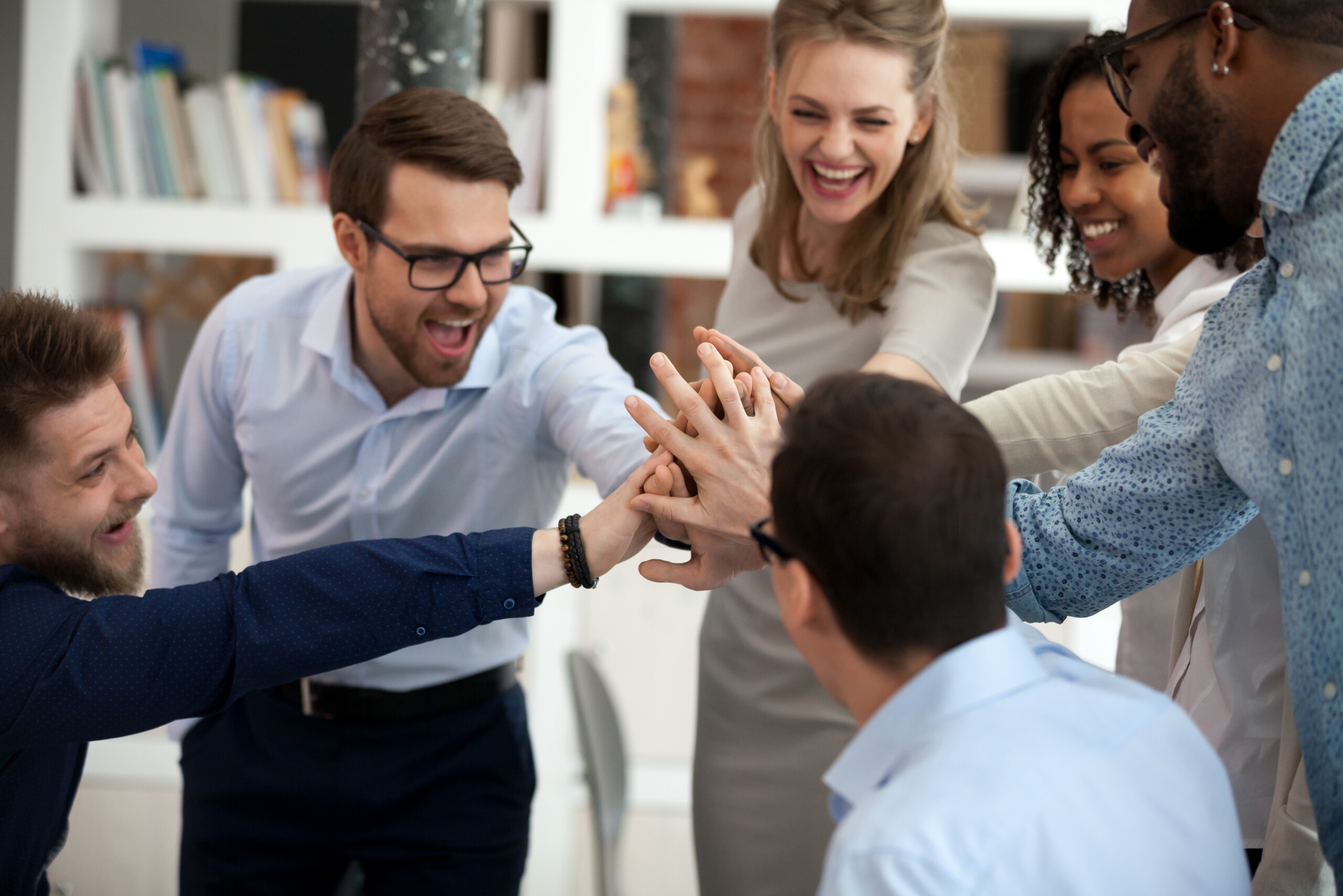 Excited motivated team give high five in office