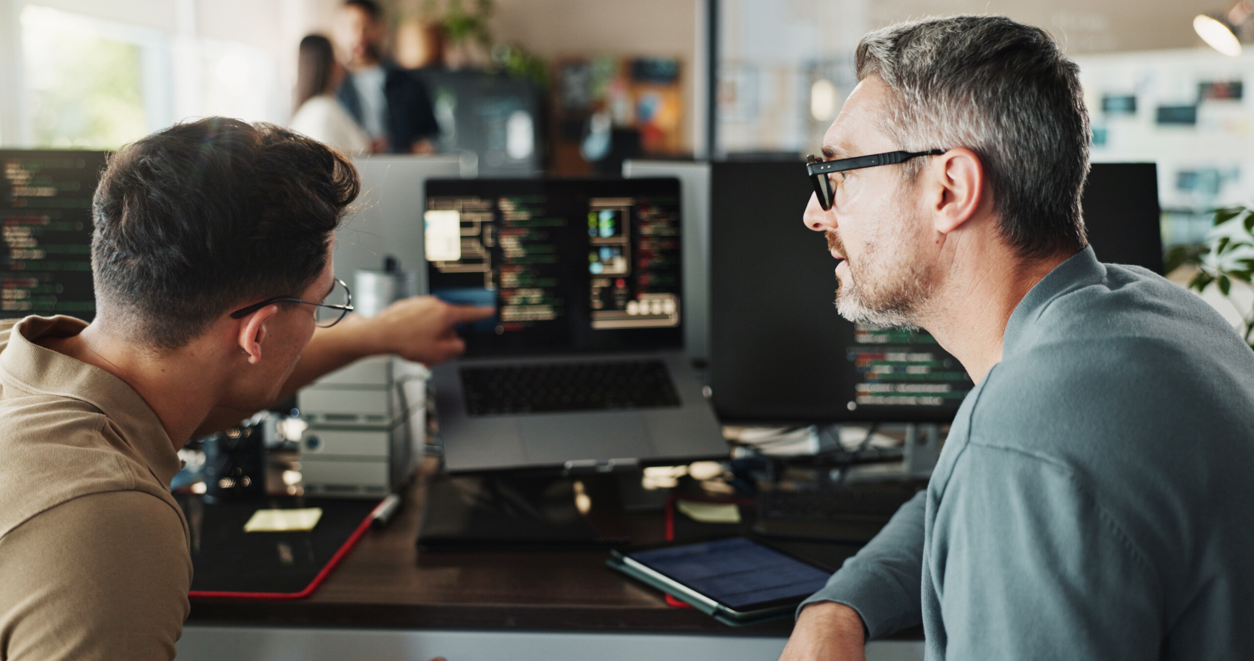 Developer and coding support on computer screen in office