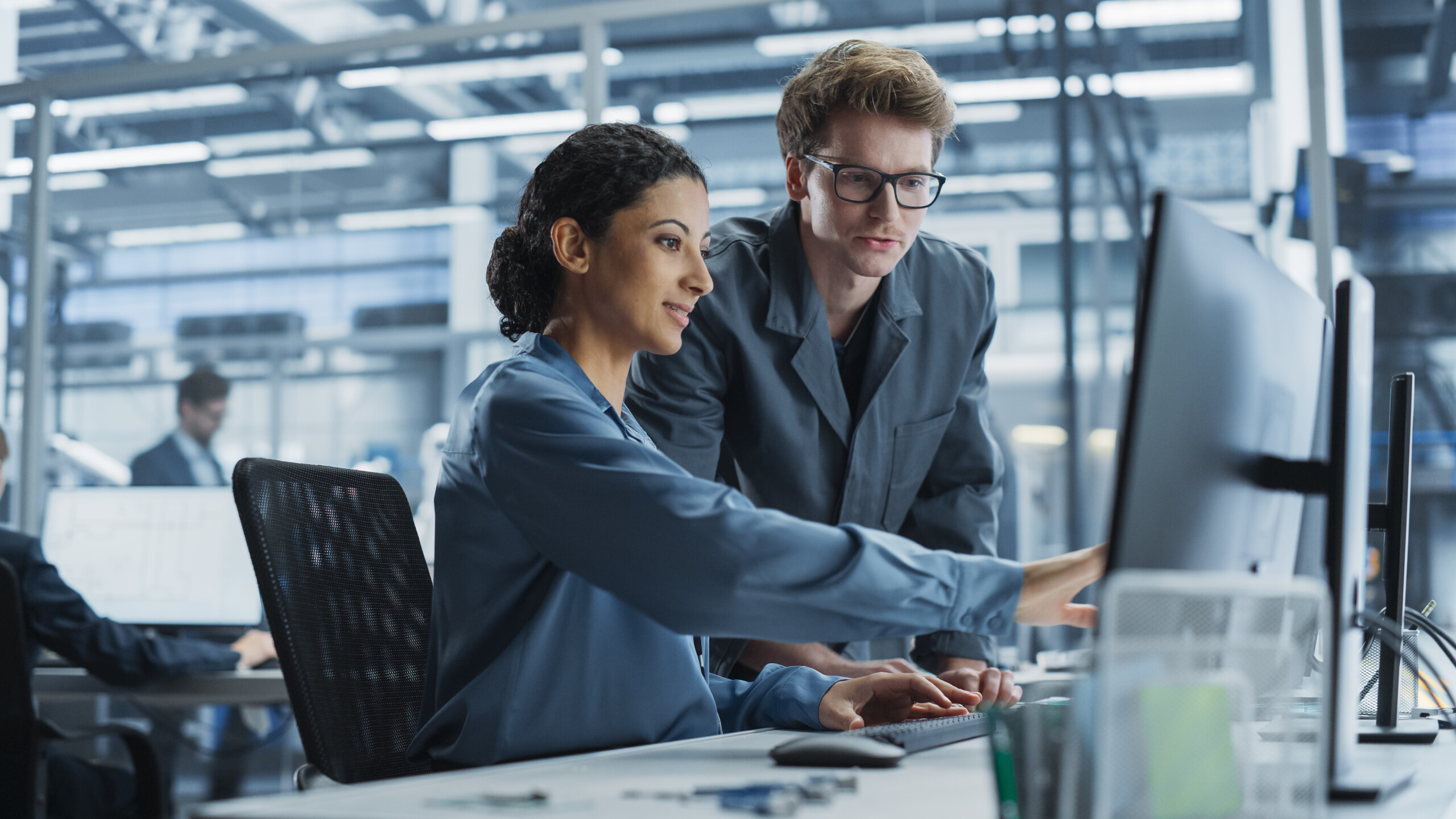 Employees Working Together Using Desktop Computer for Supervising Work Process in Automated Factory