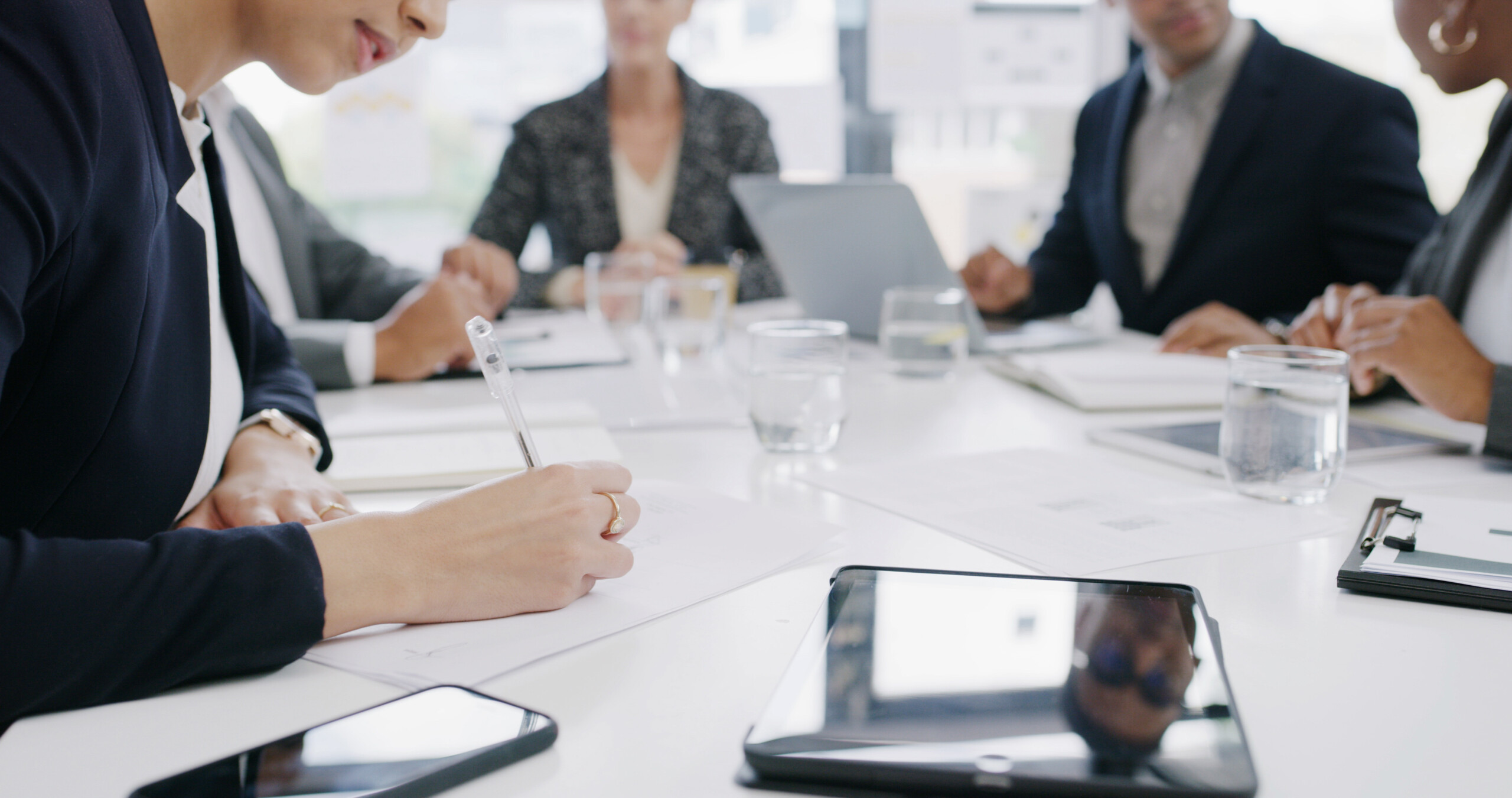 Business woman writing on document in meeting with signature contract agreement and compliance
