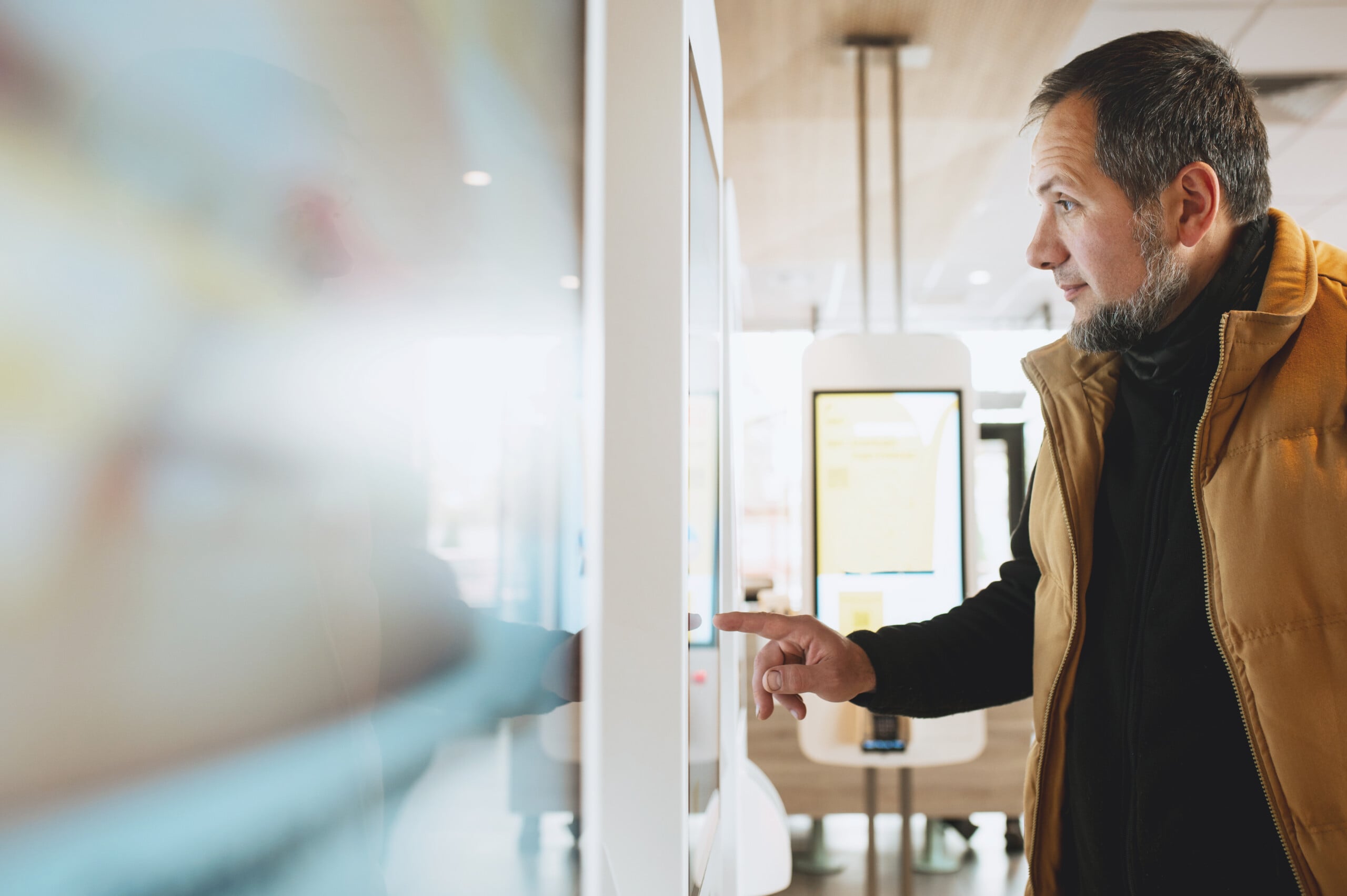 Man using self-service touchscreen kiosk