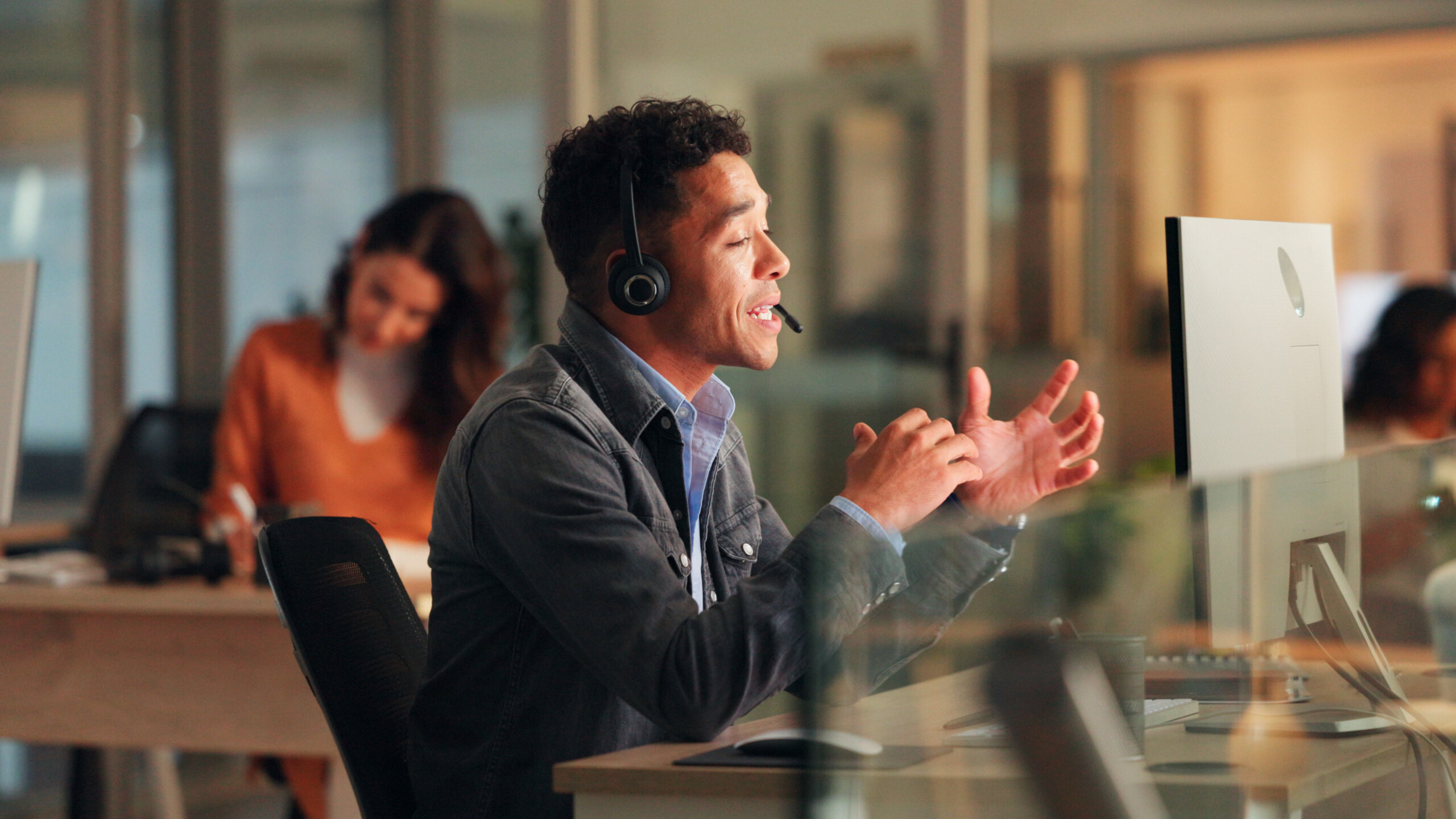 Man with a headset with computer in call centre for customer service