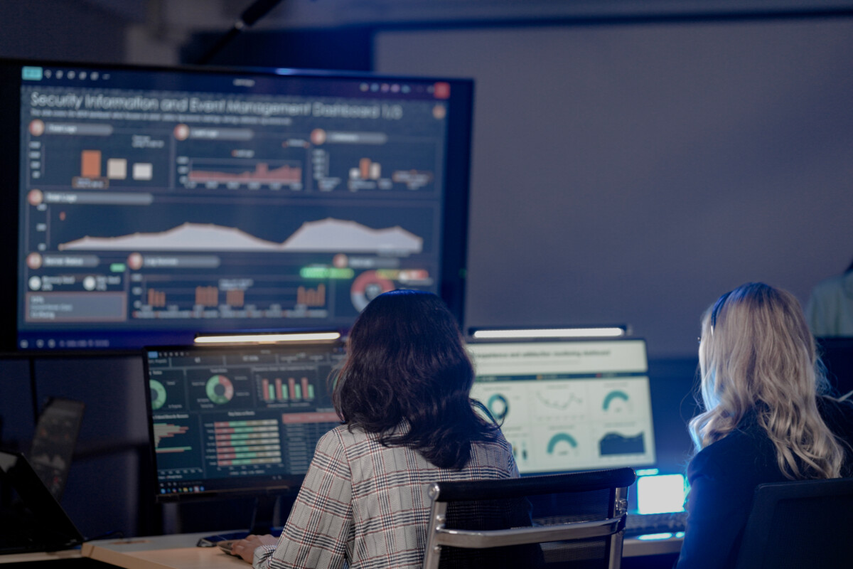 analysts monitor world map threat intel screens