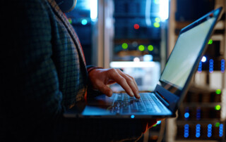 IT technician checking the servers vitals using laptop computer