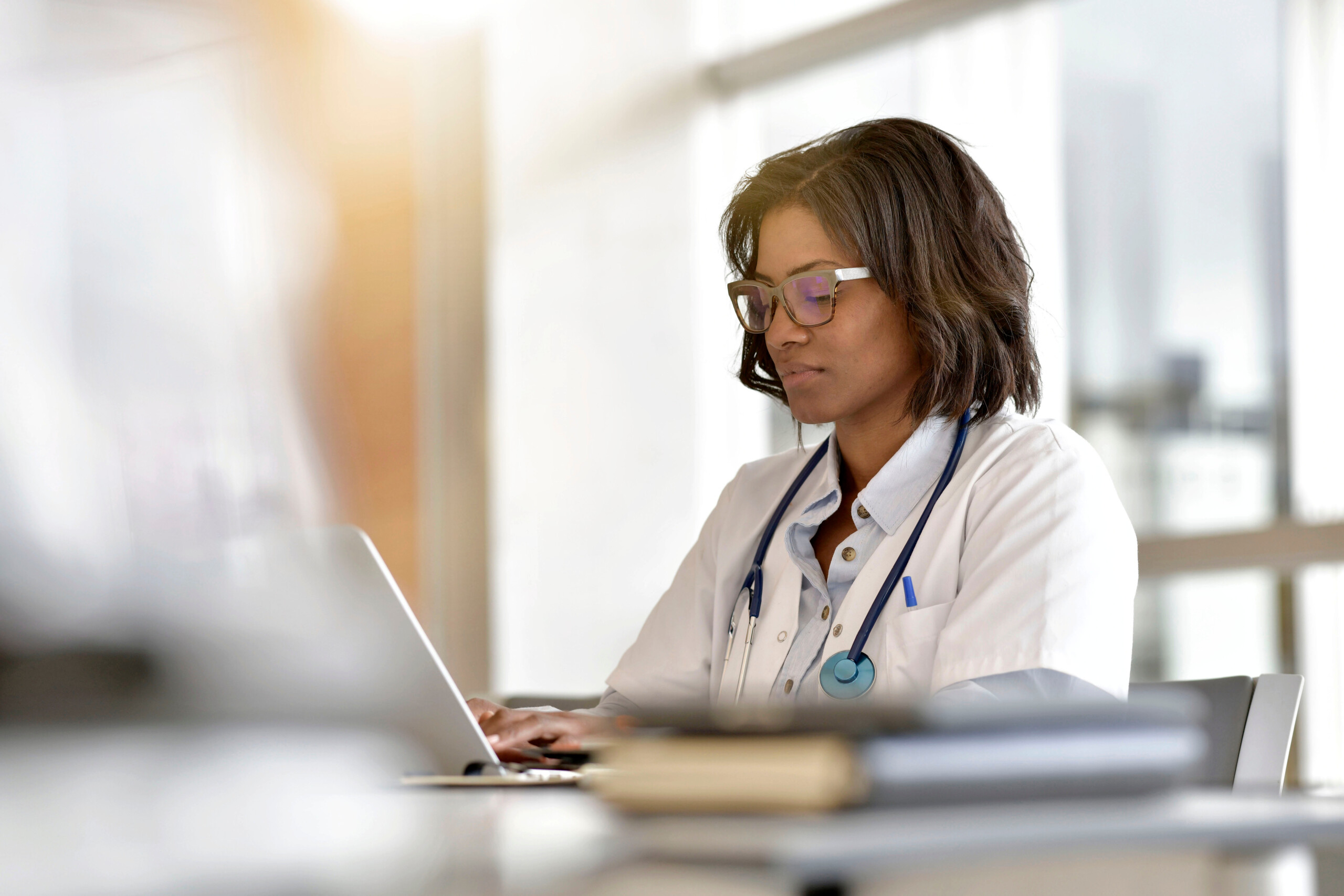 Woman doctor working in office with laptop