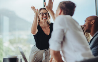 Businesswoman giving a high five to a colleague in meeting