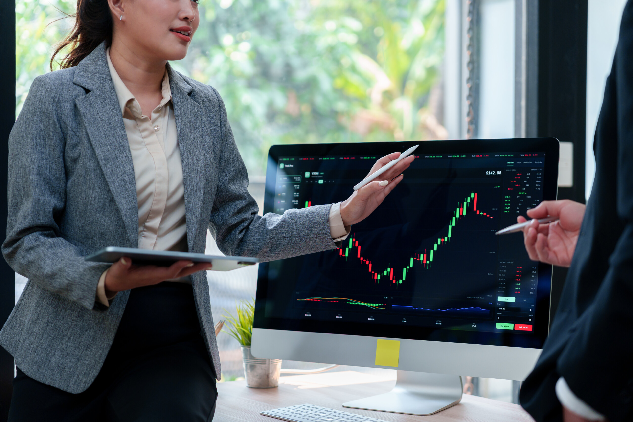Financial advisors analyzing stock market data on computer screen